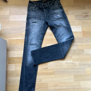 Jack & Jones svarta slim jeans - Säljer ett par svarta slim fitt jeans från Jack & Jones med slitna detaljer och snygg tvätt. Jeansen har fem fickor, dragkedjegylf och klassisk design. Materialet är jeans med stretch för extra komfort. Perfekta för dig som gillar en smalare passform och streetig look.