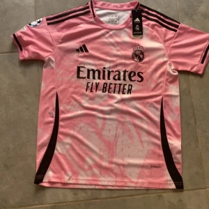 Real Madrid Mbappé rosa matchtröja Adidas - Rosa Real Madrid fotbollströja från Adidas med Mbappé och nummer 9. Tröjan passar M och S. Tröjan är helt Ny och pris kan diskuteras vid snabb affär 