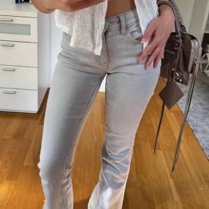 Ljusgrå flare jeans - Snygga ljusgrå jeans med flare passform och medelhög midja. Materialet är mjukt och stretchigt. Endast använda en gång så i princip nya! 