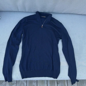 Marinblå stickad tröja Stenströms - Snygg marinblå stickad tröja från Stenströms med half zip och ribbade muddar. Tröjan har lång ärm och klassisk passform, perfekt till lager-på-lager. Materialet är mjukt och känns lyxigt mot huden. Storleken är M men de går jätte bra att använda den som S oxå. Nypris 1700. Köparen står för frakt!