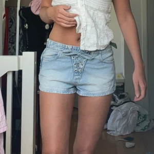 Ljusblå jeansshorts med snörning - !!INTRESSEKOLL!!                                                       Snygga ljusblå jeansshorts med cool snörning framtill i midjan. Storlek 38 men små i storleken, skulle uppskatta till storlek S