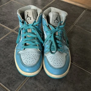Nike Air Jordan 1 blå och vita sneakers - Nike Air Jordan 1 sneakers i blått och vitt skinn med klassisk Air Jordan-logga på hälen. Helt okej skick då dem är lite använda. De är äkta. Skriv vid frågor.