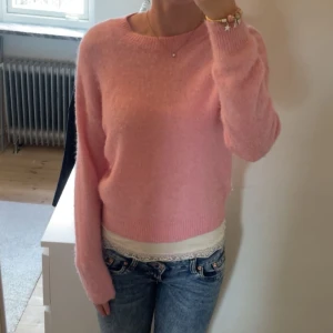 Rosa stickad tröja från MSCH Copenhagen - Supermjuk och fluffig rosa stickad tröja från MSCH Copenhagen. Tröjan har rund halsringning, ribbade muddar och en relaxed passform. Perfekt att styla med jeans eller kjol för en söt och trendig look. Nypris ca 500kr