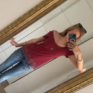 Vinröd topp med spetskant - Vinröd topp från Zalando med kort ärm och bred, rundad urringning som kan bäras offshoulder. Jättefin spetskant längst ner på plagget! Säljes pga att den inte kommer till användning men har annars inga defekter och har bara används ett fåtal gånger💕skriv för frågor!
