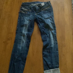 Miss Sixty blå jeans med kedjedetalj - Snygga blå jeans från Miss Sixty med coola slitningar och kedjedetalj vid fickan. Jeansen har klassisk femficksdesign, kontrastsömmar och Miss Sixty-logga på bakfickan. Modellen är rak och materialet är klassiskt jeans i bomull.