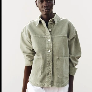 Jeansjacka - Snygg ljusgrön overshirt med klassisk krage och stora fickor framtill. Jackan har knappar hela vägen och en avslappnad, loose passform. Perfekt att slänga över en t-shirt för en chill look.