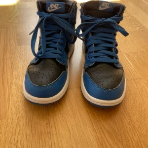 Nike Air Jordan 1 | Marine Blue - Säljer ett par Nike Air Jordan 1 Marine Blue. blått och svart med vita detaljer. Klassisk hög modell med snörning och rund tå. Perfekta för dig som gillar streetwear och vill sticka ut med snygga färger. Dom är Lite använda men inte mycket. Jag har tyvär inte kvar lådan till skorna bara så ni vet. Säg till om du har den minsta frågan om skorna. Lägg gärna ett bud om du är intresserad!