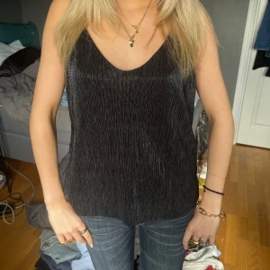  glittrig linnetopp - Snygg svart linnetopp med glittrig finish och v-ringad halsringning. skriv föf fler bilder eller frågor💞💞