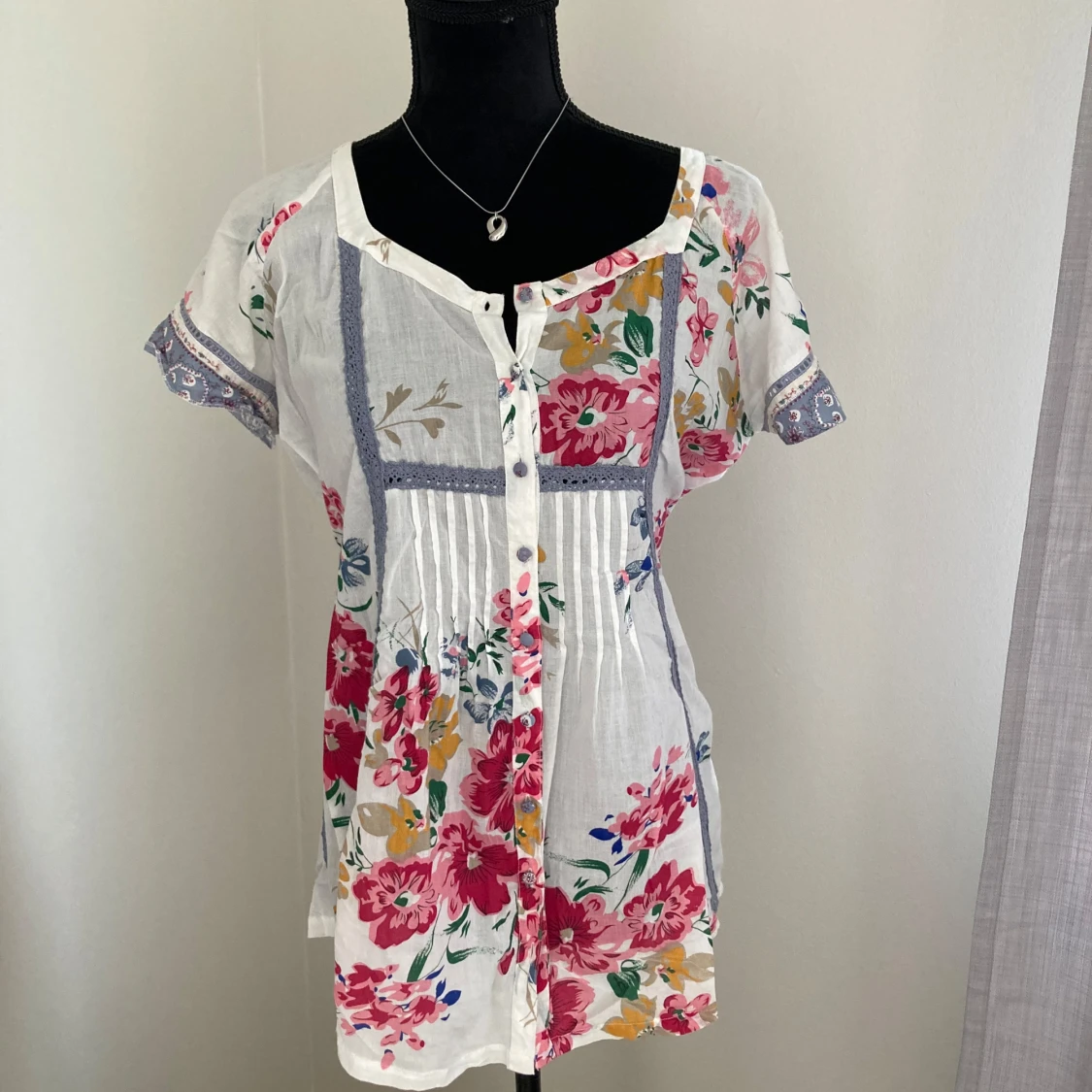 Vit blommig blus med knappar och knytband