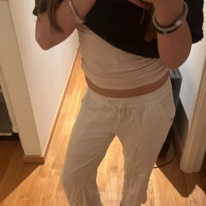 Vita linnebyxor med resårmidja - Säljer ett par vita linnebyxor med resår i midjan och raka ben. Byxorna har fickor på sidorna och en på baksidan som är perfekta för varma dagar. Lätta och luftiga, passar till många olika stilar.