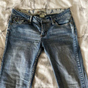 Lågmidjade Jeans - YMI Jeans - Jag säljer ett var underbara lågmidjade jeans som är bootcut! De är detaljerade med fickor både fram och bak. Jag säljer dessa då de är för små för mig😊 De är perfekta i längden och smått trasiga i slutet, kan skicka mer bilder!! Köpta från Vinted för 470kr. Står storlek 7 men passar S                                                            Midjemått: 38 cm Innerbenslängd: 79 cm 