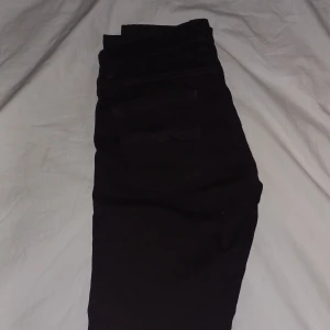 Svarta jeansbyxor från Nudie Jeans - Säljer ett par svarta jeansbyxor från Nudie Jeans med klassisk femficksdesign och diskret broderad bakficka. Byxorna har normal passform och raka ben, perfekta till vardags. Stängs med dragkedja och knapp. De är storlek W30 L32 dem är inte andvänd så mycket jag är prutbar vid snabbaffär skriv om du har några frågor eller funderingar!