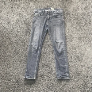 Tiger of Sweden Jeans - Säljer ett par grå jeans från Tiger of Sweden, modell Pistolero. Jeansen har klassisk femficksdesign, raka ben och normal passform. Perfekta för dig som gillar stilrena och tidlösa jeans med snygg tvätt. Jeansen är väldigt sparsamt använda. Skick 8.5/10.  Jag kan sänka priset vid snabbköp!