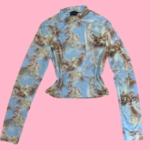 Blå topp  med änglamotiv  - Blå långärmad topp från PrettyLittleThing. Toppen har används sparsamt och är nästan som ny 🩷✨ 