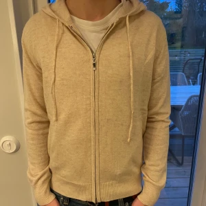 Kashmir/Merinoull Zip Hoodie - En skitsnygg Kashmir/Merinoull zip hoodie i storlek Xs som är perfekt inför sommaren!🌟 Den har en skitsnygg ljusare beige färg, den är bara testad, aldrig använd! Hör av dig vid intresse eller minsta fundering!🌟