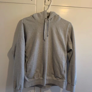 Grå hoodie från Uniqlo strl L - Grå Uniqlo hoodie i strl L. Hoodie är använd flera gånger men har inga skador eller fläckar och är därmed i väldigt gott skick. Pris kan förhandlas vid snabb affär!