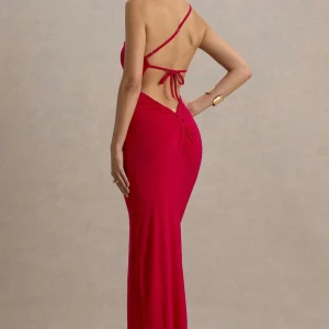 Röd oneshoulder långklänning med slits - Säljer en elegant röd långklänning med oneshoulder och öppen rygg. Klänningen har smala axelband, knytning i ryggen och en snygg slits framtill. Figurnära passform som framhäver siluetten. Perfekt för bal. Är inte använd och lapp finns kvar då. Den är köpt för 1300kr men säljer den då den var för stor för mig. 