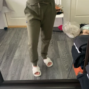 Olivgröna mjukisbyxor från Björn Borg - Olivgröna mjukisbyxor från Björn Borg med en liten svart logotyp på benet. Byxorna har normal passform, resår i midjan och är tillverkade i mjukt material som passar perfekt för avslappnade dagar.