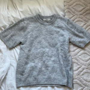 Grå stickad t-shirt - Grå stickad T-shirt från h&m barnavdelning, storlek 146/152, säljer då den inte används men i jätte bra skick och knappt använts💘