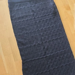 Svart stickad långkjol från Vero Moda - Säljer en svart stickad långkjol från Vero Moda. Kjolen har ett diskret mönster i stickningen och bred ribbad midja för extra komfort. Perfekt för dig som gillar en klassisk och stilren look.