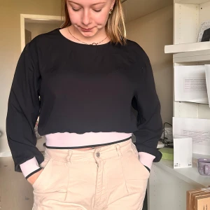 Svart croppad långärmad tröja - Säljer en svart croppad långärmad tröja med enkel design. Tröjan har rund halsringning och är perfekt för en avslappnad stil. Passar bra till både jeans och kjol.