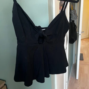 Svart topp med knytning i fram - Svart topp med knytning i fram från Gina tricot i storlek s🥰 