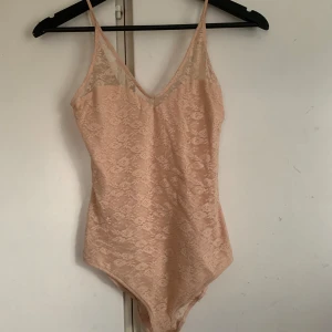 Ljusrosa spetsbody 🌸💗 - Säljer en ljusrosa body i spets med smala axelband och v-ringning både fram och bak💕 Ser lite konstigt ut på bild men sitter fint på 💕💕💕står ingen stl men sitter som en xs/s🫶🏻