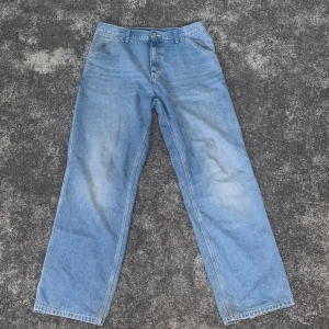 Ljusblå jeans från Carhartt - Snygga blåa heans från Carhartt (31 x 34). Superfint skick. Väldigt sparsamt använda och jag inga defekter utom lite slitage längst ner, något som jag personligen inte tycker är några problem alls. Köpta för 1350kr. Bara o skriva om man har några frågor🔥!