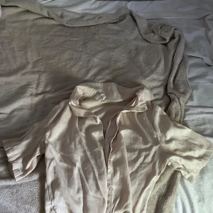 Beige kortärmad skjorta med krage - Säljer en beige skjorta med korta ärmar och klassisk krage. Skjortan har knäppning framtill och är croppad i modellen, vilket ger en avslappnad och trendig look. Perfekt att styla med både jeans och kjol🥰 Om du är intresserad skriv till mig , betalning sker via swish! ☺️