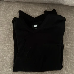 Svart merinoullströja med v-ringning från WE - Snygg svart tröja i 100% merinoull från WE. Tröjan har v-ringad hals och långa ärmar, perfekt för lager-på-lager eller som den är. Enkel och stilren design som passar till det mesta.