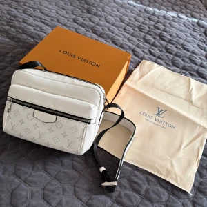Louis Vuitton axelväska - Säljer en snygg vit axelväska från Louis Vuitton. Väskan har silverfärgade detaljer, dragkedja och justerbar axelrem. Perfekt storlek för dem flesta passar jätte bra på sommrarna speicllet utomlands. Endast testad (helt ny) först till kvarn 4500kr 