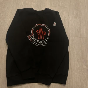 Moncler hoodie svart M - Jag vill sälja denna tröjan eftersom den var liten på mig, helt nyskick använd fåtal gånger, hör av er om ni är intresserade!