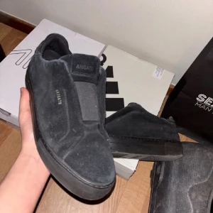 Svarta sneakers från Axel Arigato - Stilrena svarta sneakers från Axel Arigato i mocka. Perfekta för dig som gillar en clean look. 360 Clean. Det kommer med box och är rengjorde innan ni köper 😊Storlek 42 men passar mer 43