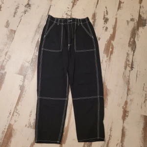 Svarta byxor med vita sömmar från H&M Divided st 40 - I bra begagnat skick