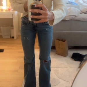 Blå bootcut jeans från Levis - Säljer ett par  blå bootcut jeans från Levis . Jeansen har låg  midja, lätt slitna detaljer vid knäna och en snygg passform. 