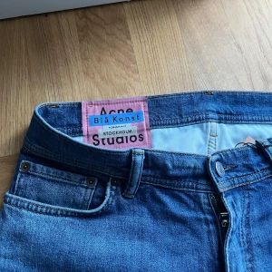 Acne jeans nyskick - Säljer ett par klassiska blå jeans från Acne Studios Blå Konst. Jeansen har normal passform, raka ben och fem fickor. Stängs med dragkedja och knapp. Perfekta till vardags och har en snygg tvättad blå färg. Väldigt limiterade byxor i nyskick! 🙌🔥Tveka inte på att höra av er vid frågor. Kom med bud!