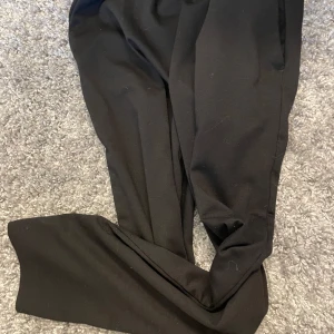 Svarta mjukisbyxor med snörning - Svarta mjukisbyxor med elastisk midja och snörning framtill. Byxorna har en avslappnad passform och är perfekta för en chill stil. Mjukt material som känns skönt mot huden.