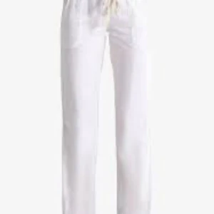 Vita linnebyxor, Roxy - Snygga och luftiga vita linnebyxor med dragsko i midjan. Perfekta för varma dagar och har en rak passform som ger en avslappnad look. Lätta att matcha med olika toppar för en stilren outfit.