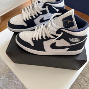 Jordan 1 mid white metallic gold obsidian - Säljer ett par helt nya och oanvända Air Jordan 1 Mid White Metallic Obsidian. Skorna är 100% äkta och kommer med originalkartong. Aldrig använda, endast provade hemma. Nypris i butik ligger runt 2200-2600.