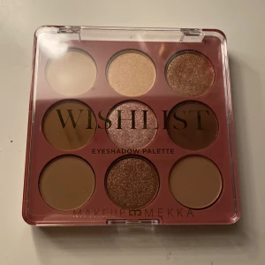 Wishlist Eyeshadow Palette från Makeup Mekka - En helt ny ögonskuggspalett med nio nyanser i både matta och skimrande toner. Färgerna går i beige, guld, brons och bruna nyanser. Perfekt för att skapa både naturliga och mer intensiva ögonlooker. Kommer i en smidig plastförpackning med transparent lock.