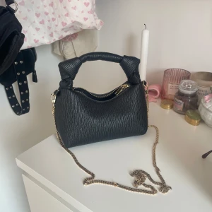 Svart handväska med guldkedja - Super söt svart handväska som man även kan ha crossbody med ett avtagbar kedjerem i guld. Den är lite mindre och får plats med mobil, nycklar osv