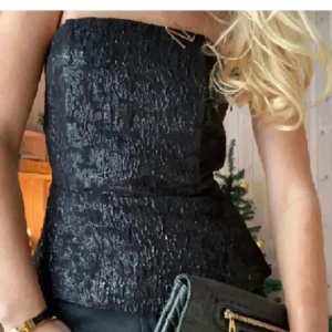 Svart tubtopp med struktur - Säljer en svart tubtopp med snygg struktur i tyget. Har endast använt den ett fåtal gånger. Den är i storlek 40 men är liten i storleken o passar någon som är 38/36. (Två första bilderna är inte mina och den sista är från hms hemsida)