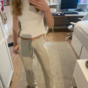 Beige linnebyxor från Roxy💞 - Säljer ett par beige linnebyxor från Roxy, nyskick och knappt använda. Byxorna har en vågig, elastisk midja och raka ben. Perfekta för sommaren❣️