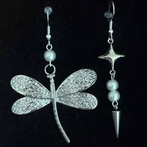 Silvriga örhängen med trollslända och pärlor - Handgjorda och unika silverörhängen 🤩 Öronhängerna är nickelfria och silverpläterade i kirurgiskt stål, resterande av örhänget är i rostfritt stål (ej silverpläterat) 💕🙏 6 cm långa. Alla köp görs via ”KÖP NU” knappen.  💐