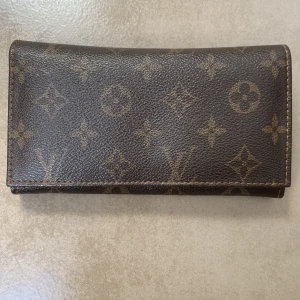 Plånbok - Den är i okej skick men har skada. Har haft en i min källare ett långt tid men rensade ut och hittade denna. Vet ej vilken storlek den är*