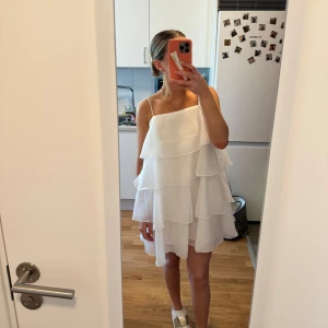 Vit volangklänning - Vit volangklänning från Gina Tricot. Köpt förra året men kom tyvärr aldrig till användning. Storlek 34, aldrig använd med prislapp kvar. Superfin till studenten, skolavslutning eller midsommar.💞☀️ Kan skicka mer bilder på klänningen privat🫶🏼