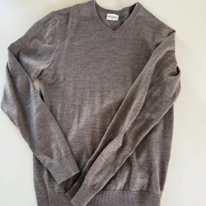 Brun v-ringad tröja från John henric  - Säljer en klassisk brun v-ringad tröja från John henric. Tröjan har lång ärm och ribbade muddar vid ärmslut och nederkant. Perfekt för lager-på-lager och enkel att matcha med olika outfits.