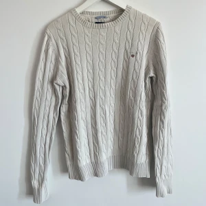 Gant stickad tröja vit  - Säljer min stickade Gant tröja i vit färg. Den vita färgen har dock slitits av tvätt och användning. 