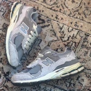 New balance 2002r protection pack Rain Cloud - Halloj! Nu finns dessa New balance 2002r protection pack Rain Cloud skorna till salu. Dem är rätt använda men ändå i väldigt bra skick med endast en defekt som man ser på sista bilden där en av häl delerna bara sitter lite lösare:). Strlk 43 och inget og följer med endast skorna kommer vid köp! 