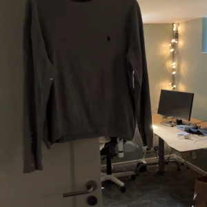 Ljusgrå stickad tröja från Ralph Lauren - Säljer min ralph lauren tröja. riktigt snygg till sommaren då den passar in. den är i riktigt bra skick och om det finns frågor så kontakta bara. priset kan diskuteras vid snabb affär 